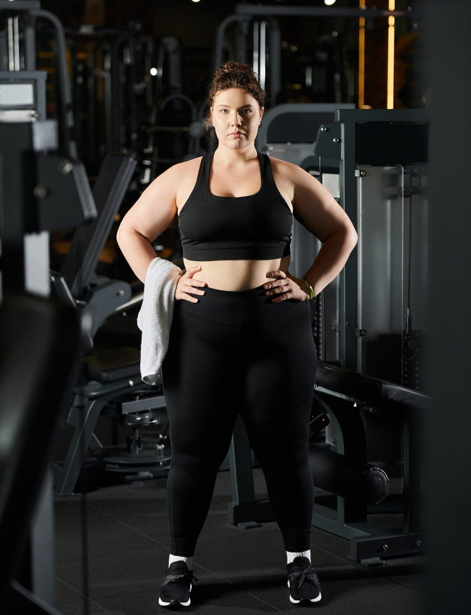 A plus-size woman confidently exercises in active wear, promoting body positivity and self-love.